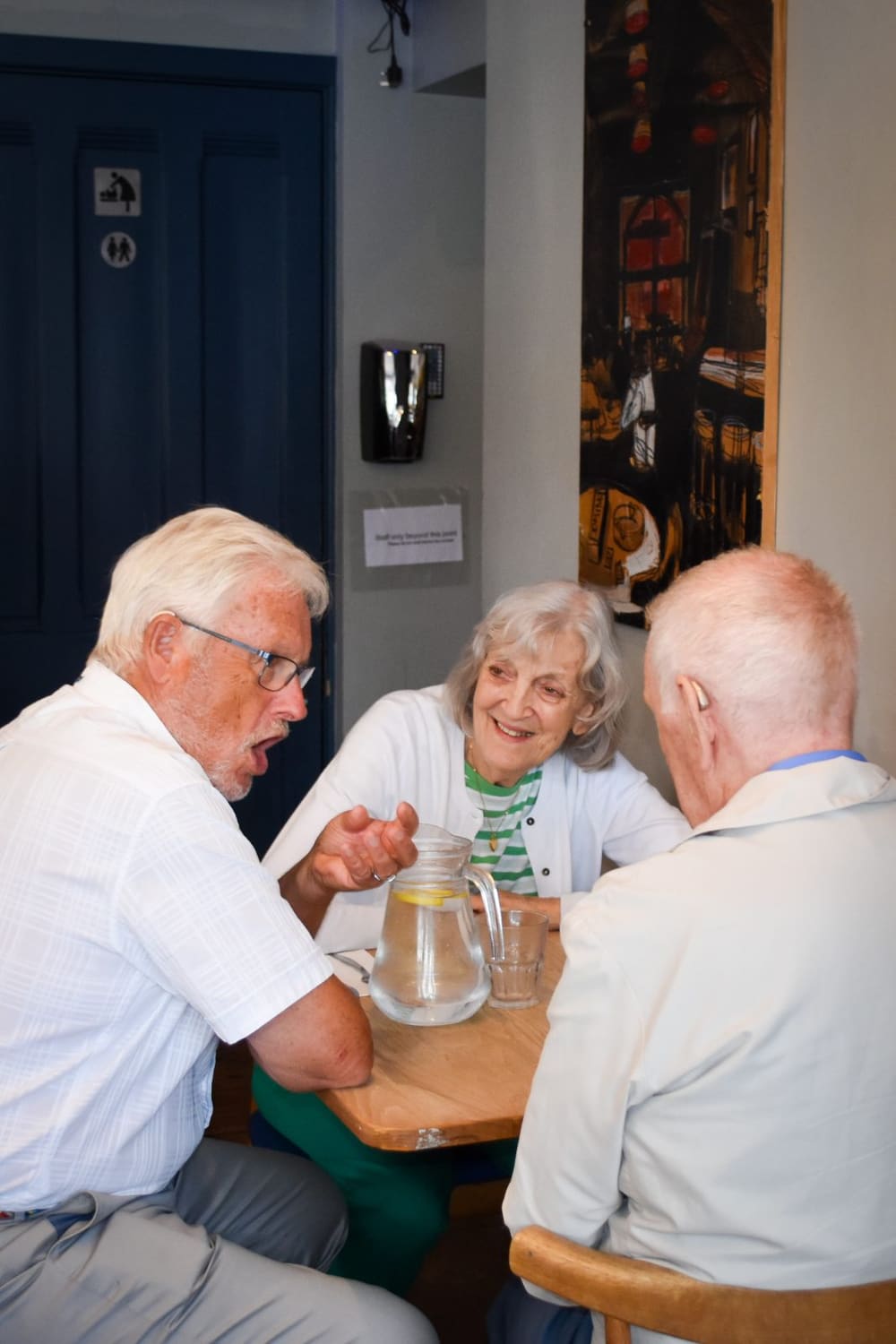 Guests laughing together over lunch at a Hearology Lunch & Listen